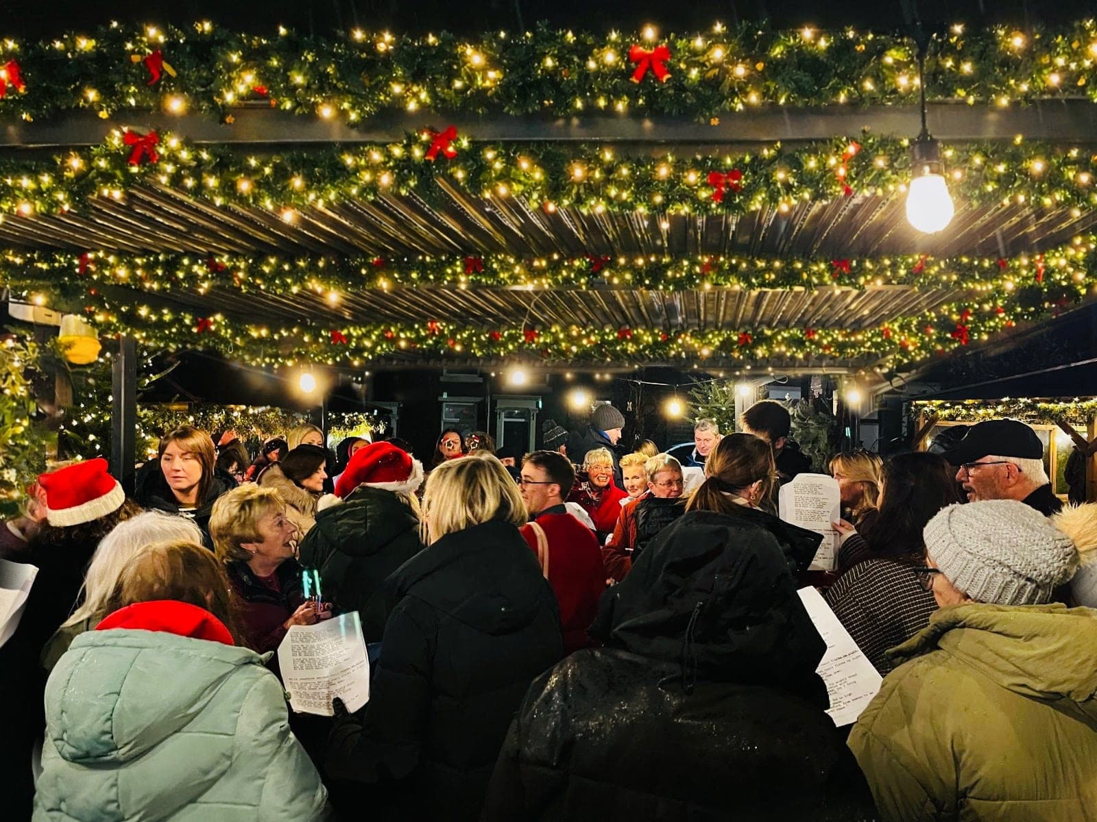 Carol singing under the pergola at Christmas